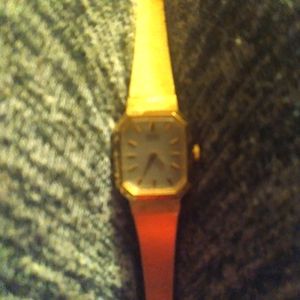 Women's watch. Gold band with clasp at the end.